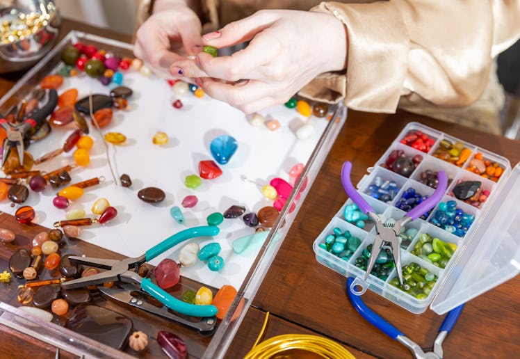 A Female Model Makes Jewelry using Beads, Pliers and Other Tools at a Workbench.  In these photos sh...