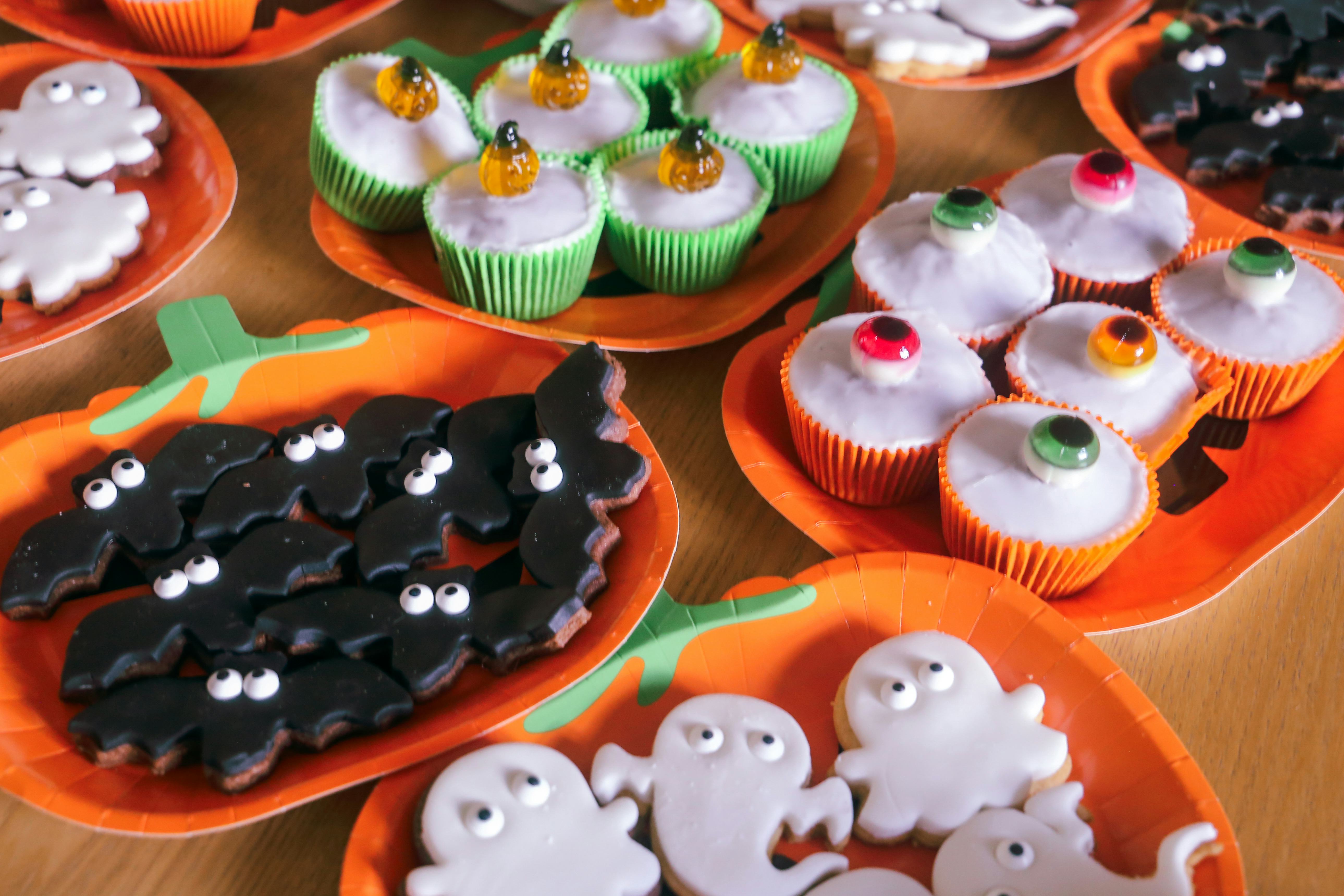 Table top with an array of home made cakes and biscuits for Halloween.