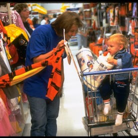 Lori Lucas showing her shopping cart-riding son Sam Halloween costume at Wal-Mart, shopping stop in ...