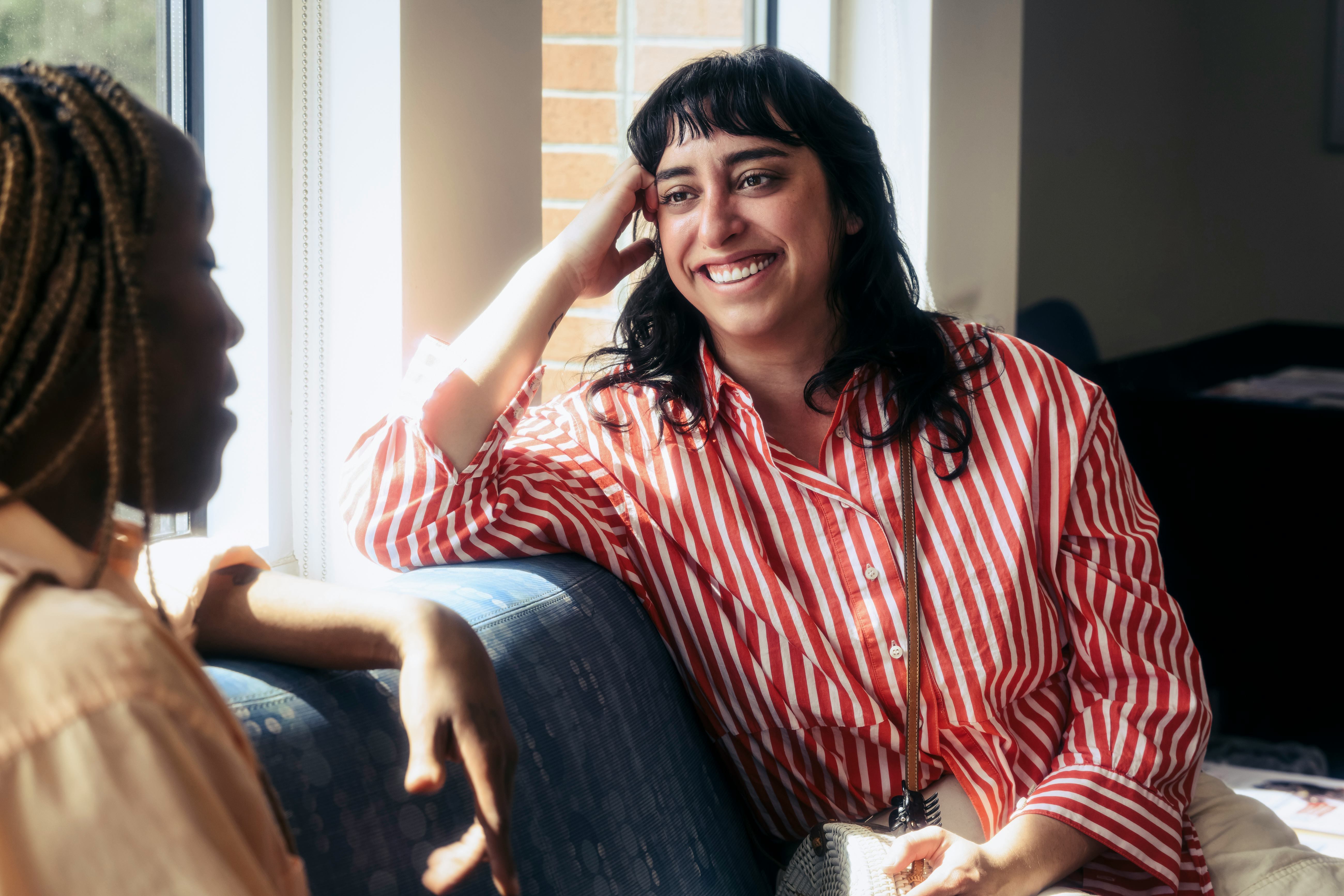 Female friends talking while waiting for appointment at doctor's office.