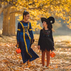 Two young girls in Halloween costumes goes to trick or treating.
