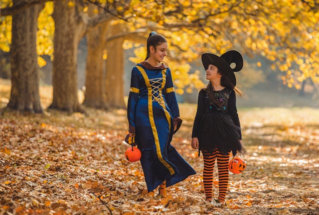 Two young girls in Halloween costumes goes to trick or treating.