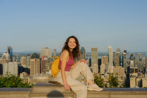 Woman looking at Montreal cityscape from Mount Royal in summer at sunset