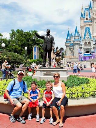Visitors have their photo taken in front of Cinderalla Castle at Magic Kingdom.
