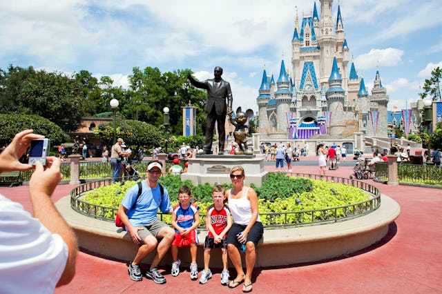 Visitors have their photo taken in front of Cinderalla Castle at Magic Kingdom.
