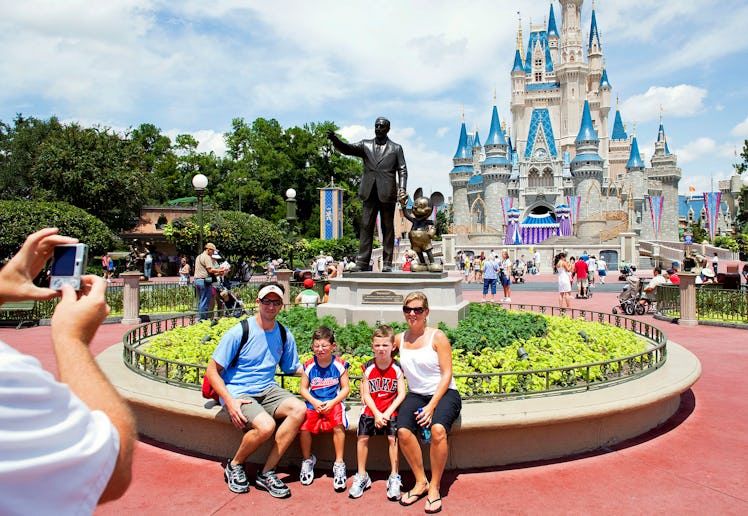 Visitors have their photo taken in front of Cinderalla Castle at Magic Kingdom.