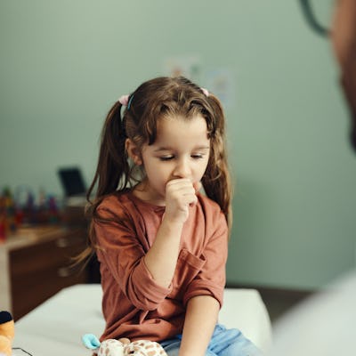 Little girl coughing in the doctor's office.