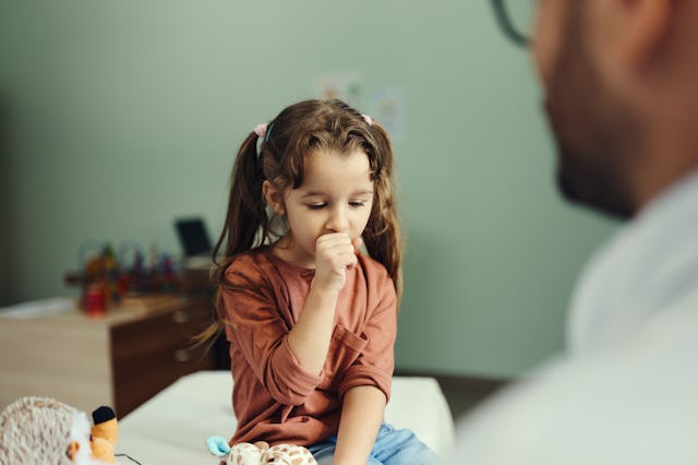 Little girl coughing in the doctor's office.