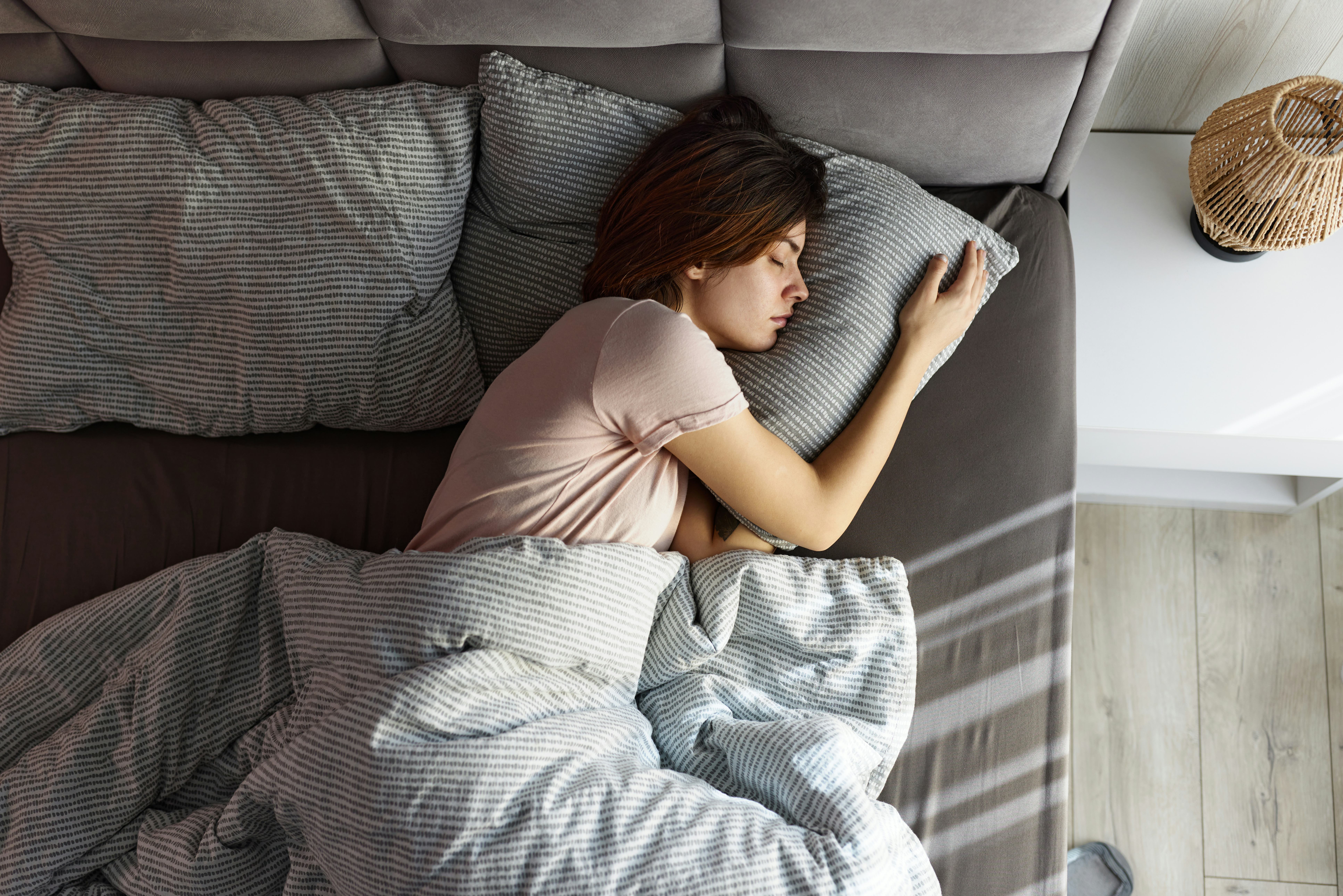 High angle view of carefree woman taking a nap in her bed.