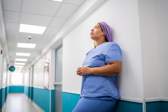 Worried mid adult nurse woman on corridor at hospital