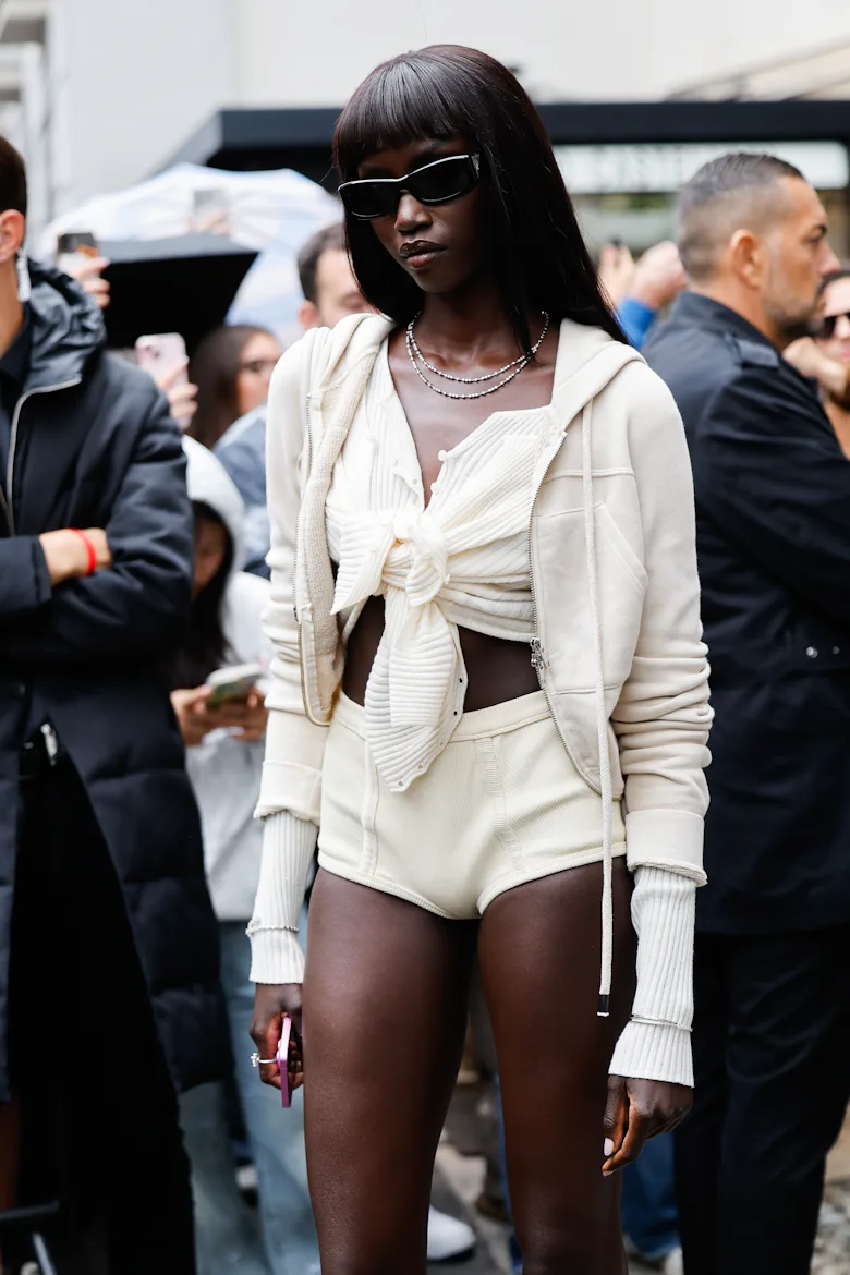 MILAN, ITALY - SEPTEMBER 27: Anok Yai wears beige crop top with a not in the front, beige micro shor...