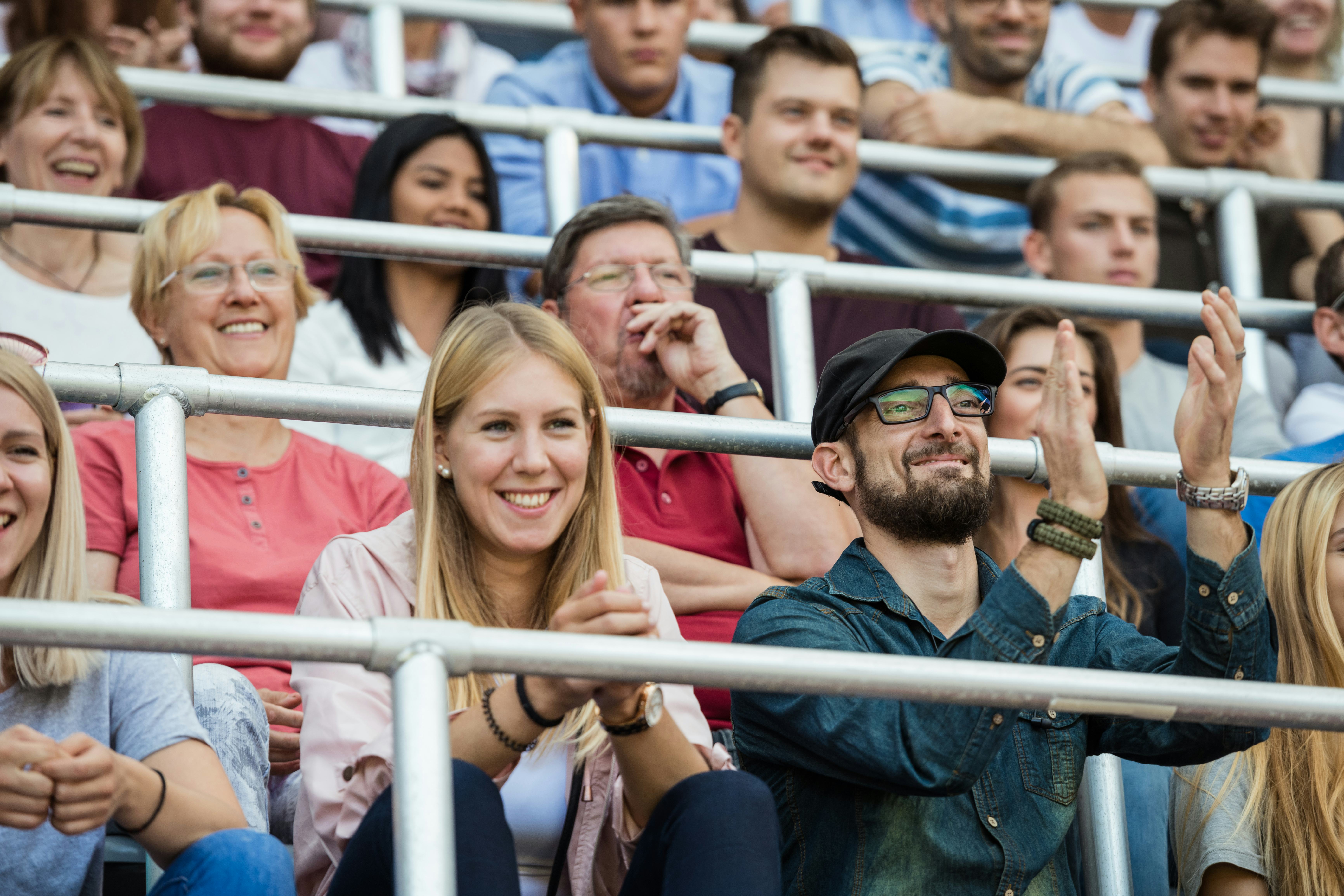 Two creative parents cheer on their athletic kid. 