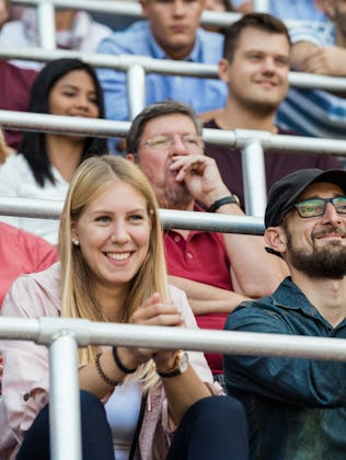 Two creative parents cheer on their athletic kid.