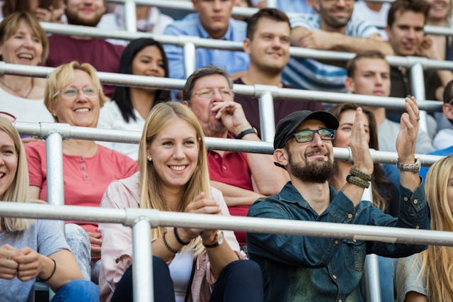 Two creative parents cheer on their athletic kid.