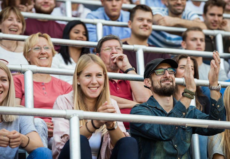 Two creative parents cheer on their athletic kid.