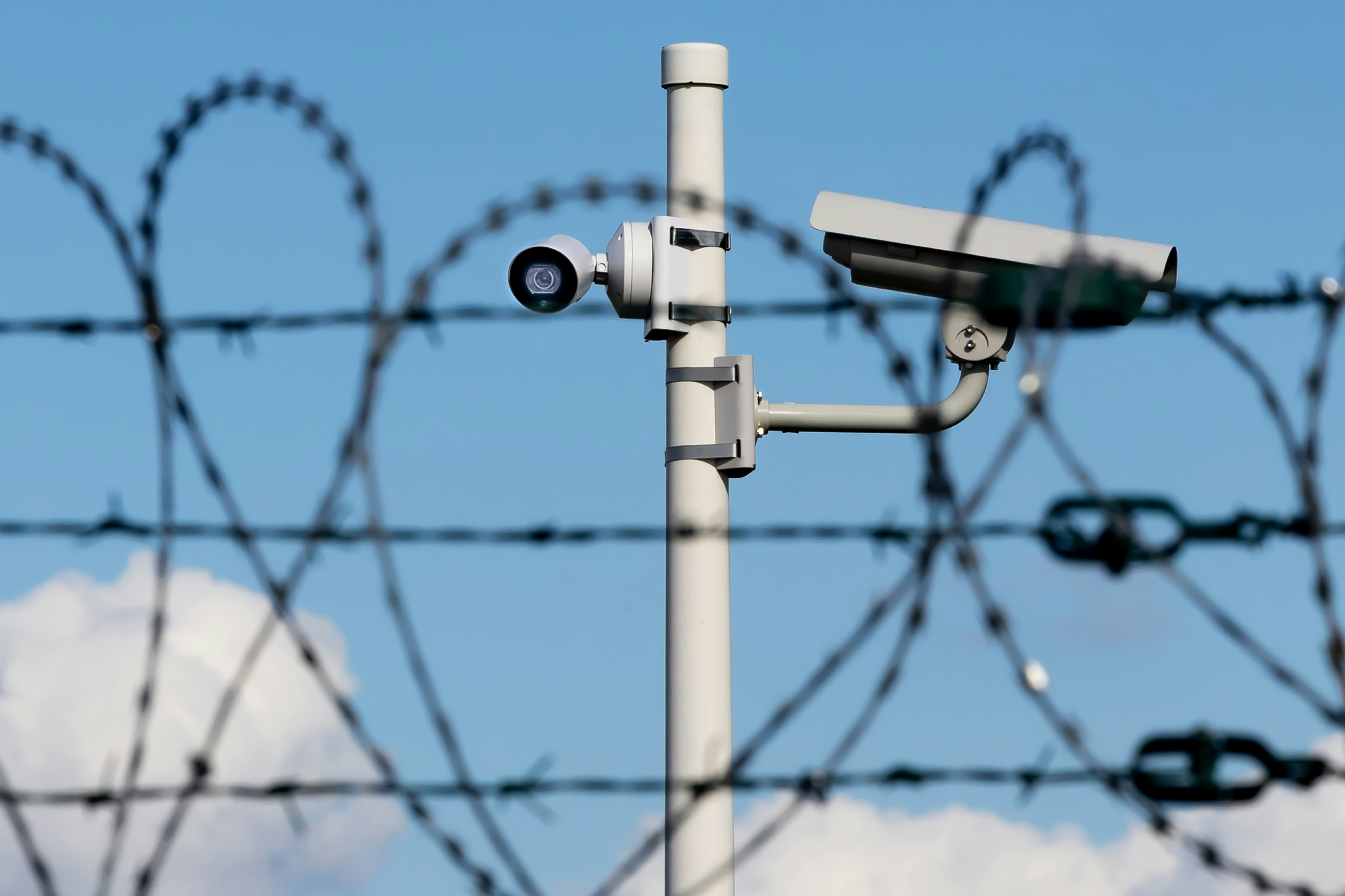 Surveillance cameras behind barbed wire