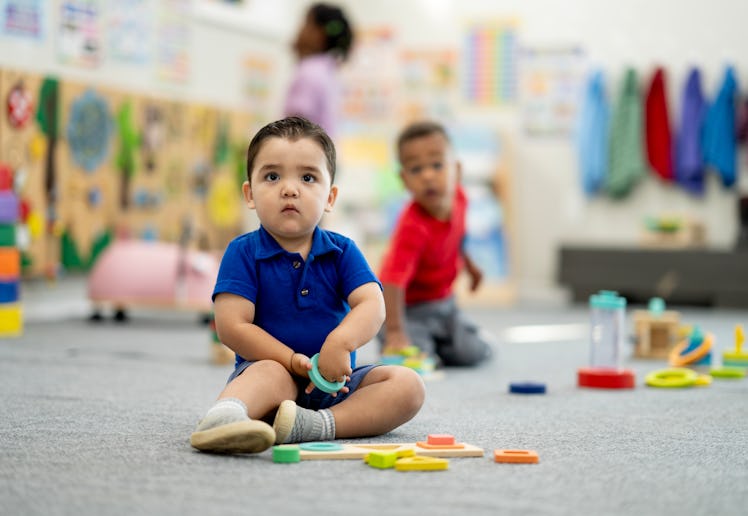 Diverse preschool scene shows curious children exploring shapes and colors with supervision, fosteri...
