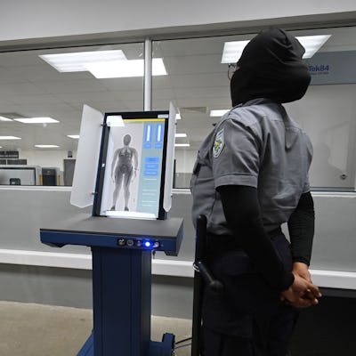 A prison security officer uses a body scanner at the newly inaugurated "Terrorist Confinement Centre" (CECOT), at a secluded rural area in a valley near Tecoluca, 74 km southeast of San Salvador, on February 2, 2023. - The 166-hectare site has a dozen pavilions covering 23 hectares and is intended to house 40,000 alleged gang members, many arrested under a state of emergency in their "war" against crime. (Photo by Marvin RECINOS / AFP) (Photo by MARVIN RECINOS/AFP via Getty Images)