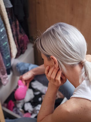 Woman reorganizing her wardrobe in her bedroom