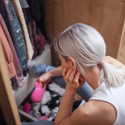 Woman reorganizing her wardrobe in her bedroom