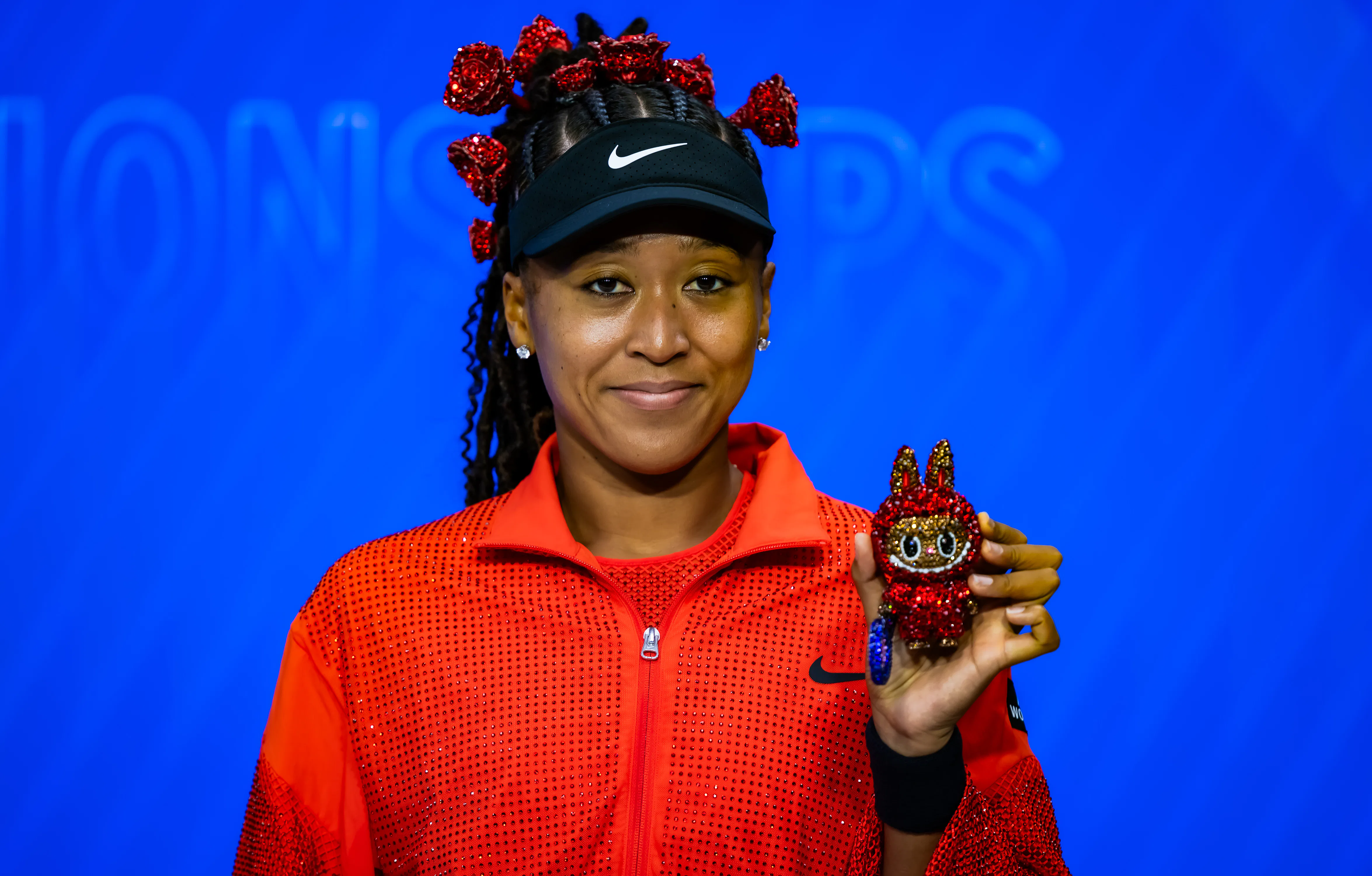 Naomi Osaka poses for a photo with her Labubu after defeating Greet Minnen of Belgium in the first r...