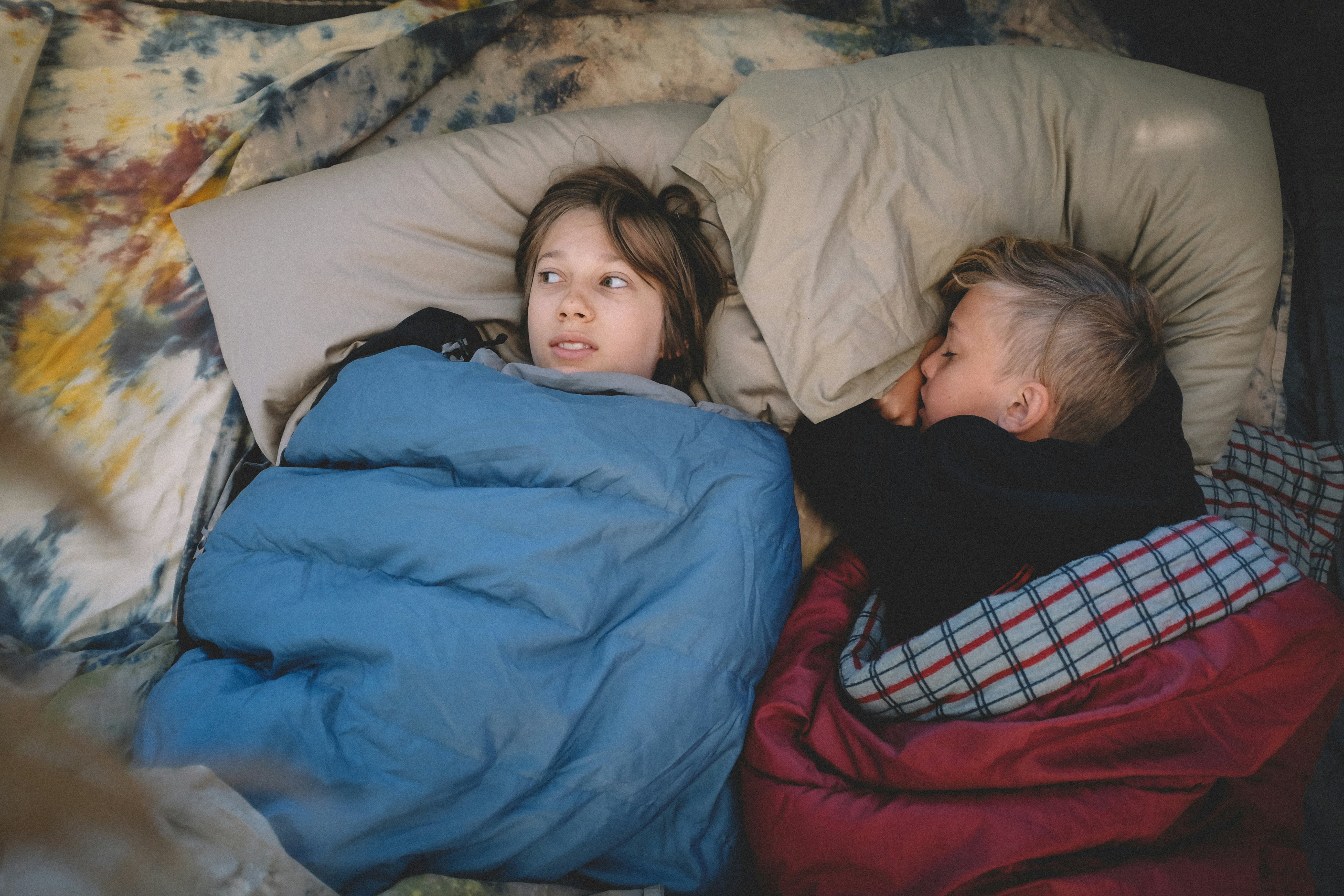 Two boys in sleeping bags at a sleepover. 