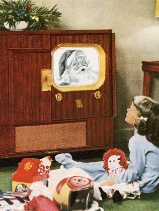 Boy and girl happily watching Santa Claus on television on Christmas day; photograph, 1950. (Photo b...