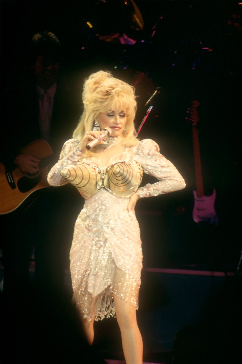 American singer and songwriter Dolly Parton poses in a brassiere contraption of two huge cones over ...