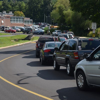Cars line up to pick up students at the end of the school day.