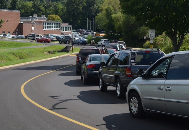 Cars line up to pick up students at the end of the school day.