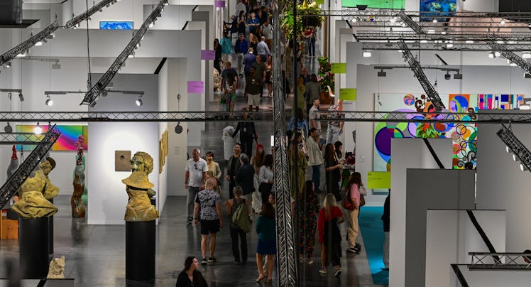People look at artwork during the 22nd edition of Art Basel at the Convention Center in Miami Beach,...
