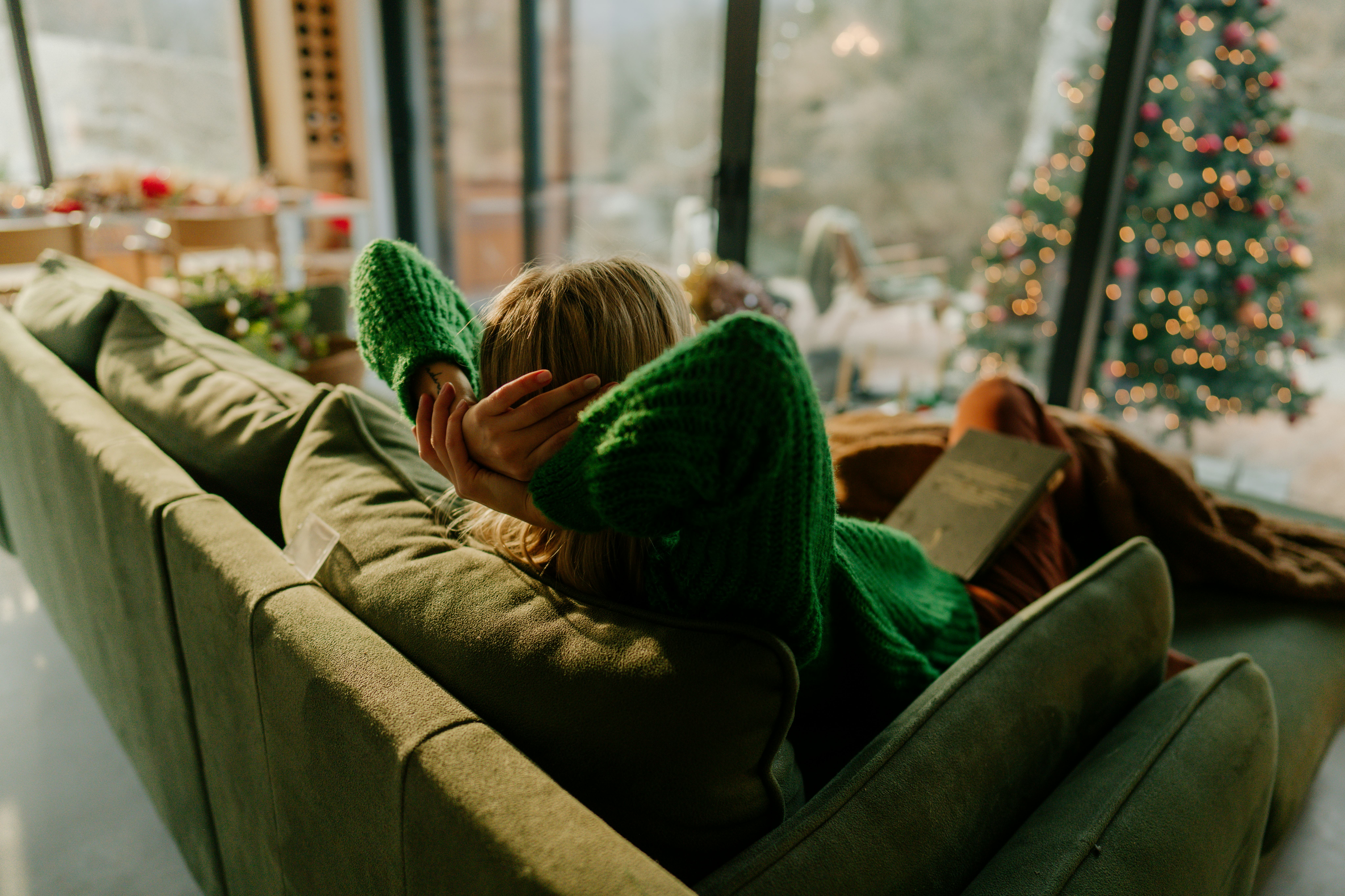 Photo of a young woman relaxing in her living room; staying in her warm and cozy home and enjoying t...