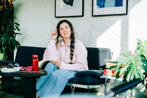 Woman thinking while writing in journal at cafe