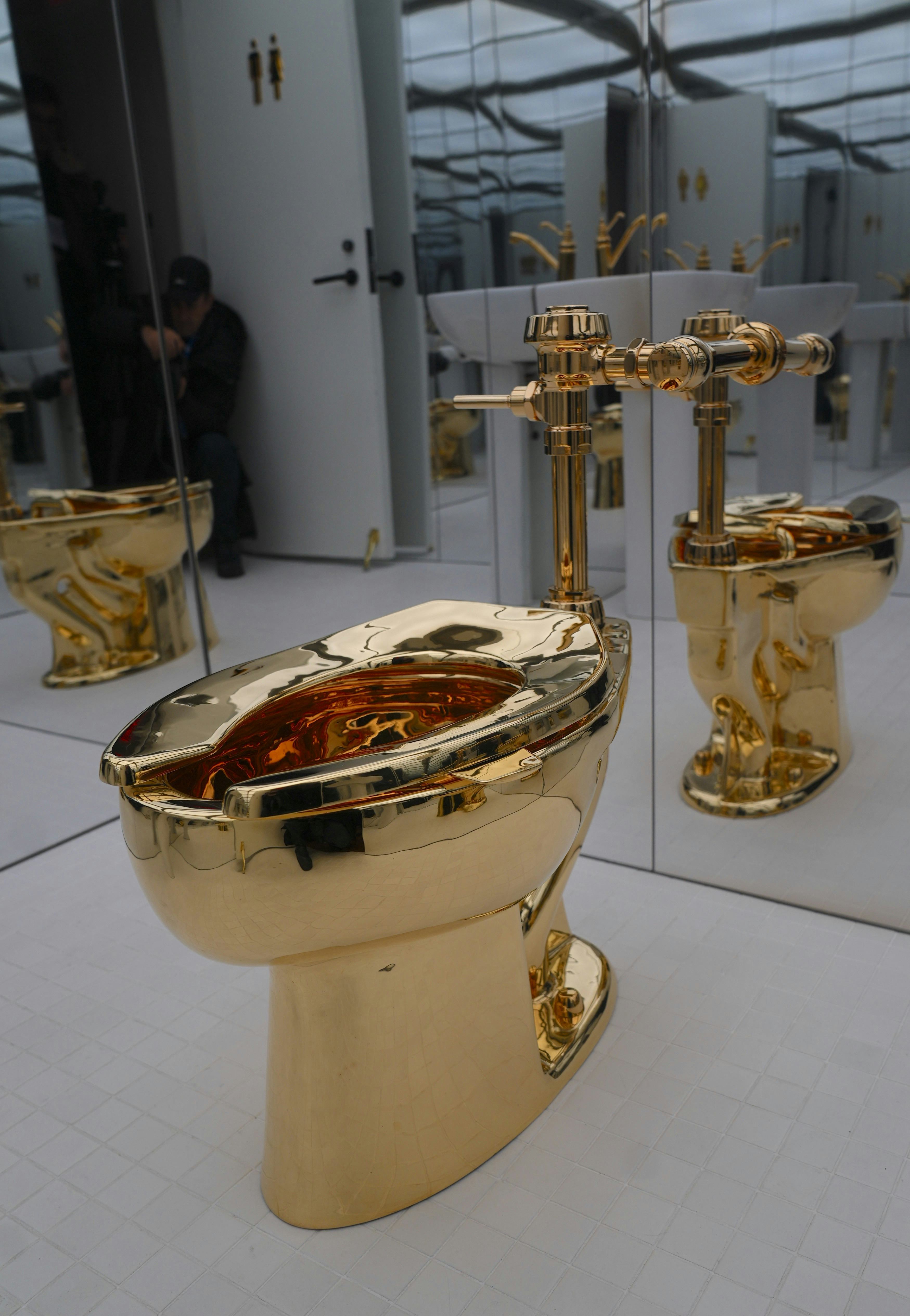 NEW YORK, UNITED STATES - NOVEMBER 17: Maurizio Cattelan's influential artwork, a solid gold toilet,...