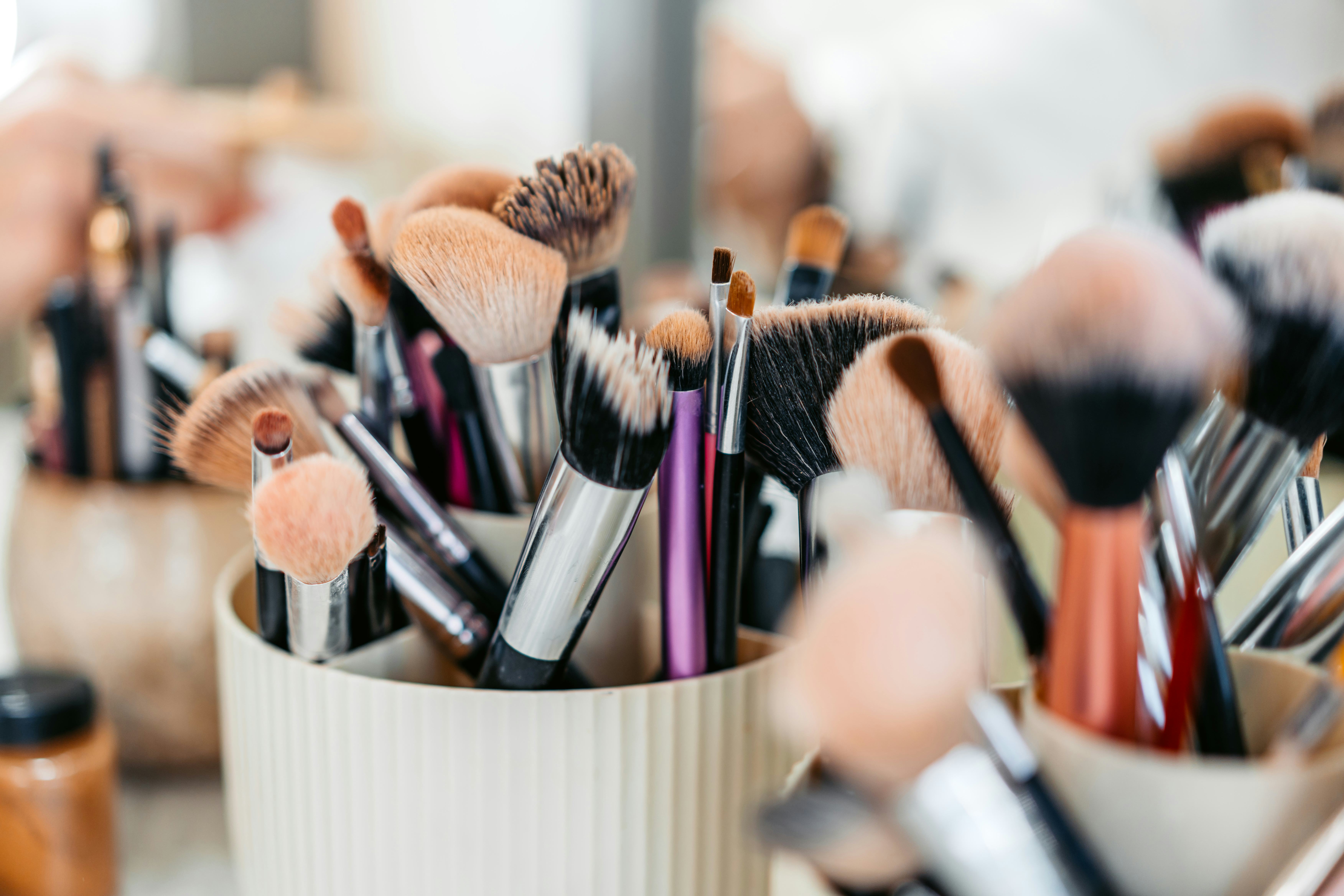 A set of makeup brushes and beauty products arranged on a desk at the beauty salon.