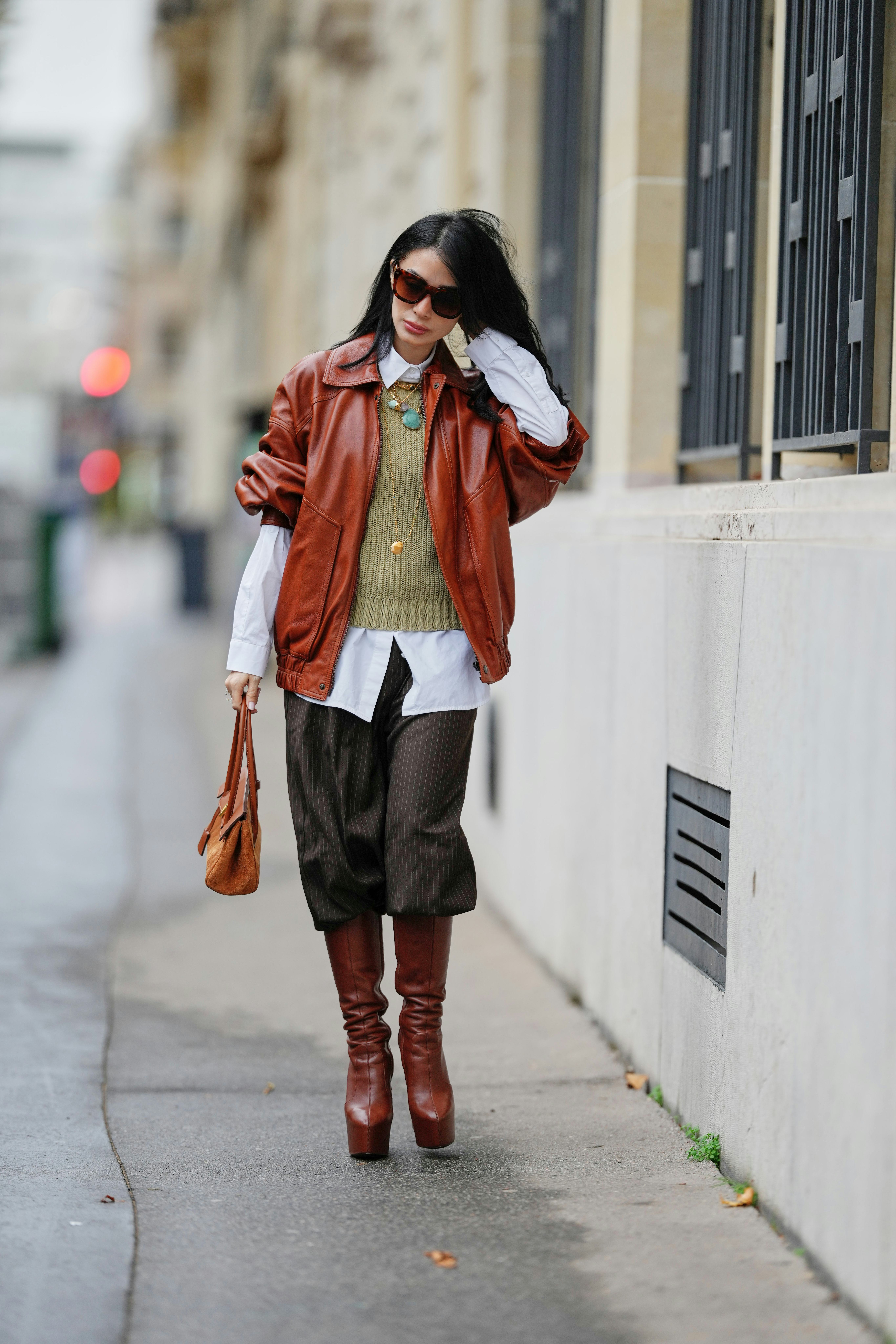 PARIS, FRANCE - NOVEMBER 07: Heart Evangelista wears long wavy black hair, a brown leather bomber ja...