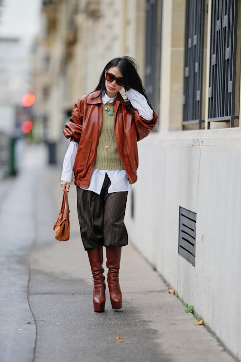 PARIS, FRANCE - NOVEMBER 07: Heart Evangelista wears long wavy black hair, a brown leather bomber ja...
