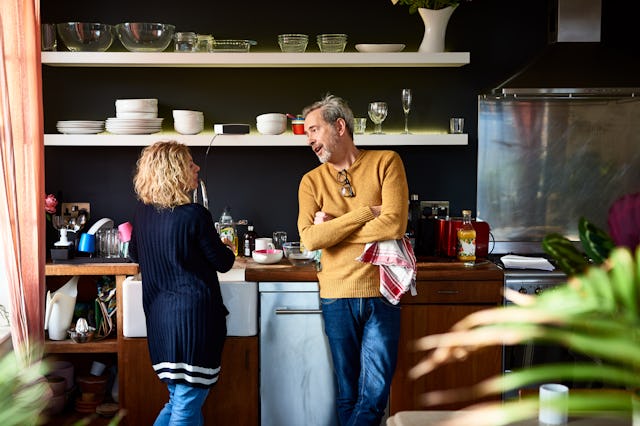 Married couple at kitchen sink having conversation, planning, togetherness, discussion