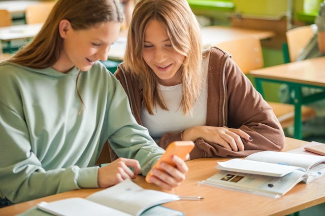High school students using smart phones while working. Students spent 25 minutes of the school day o...