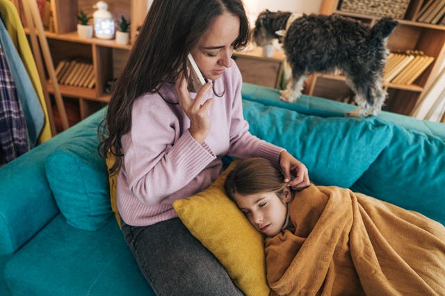 A mom sits with her sick daughter. The flu is worse than its been in 15 years.