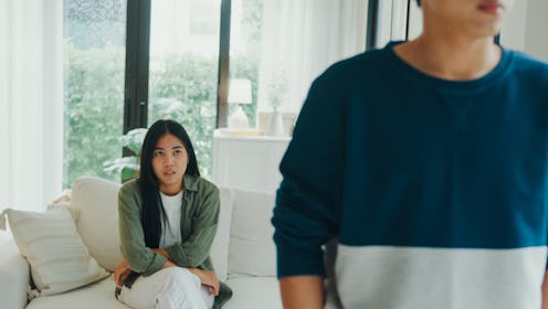 Young Asian couple angry worried quarreling arguing in living room at home. Problems in relationship...