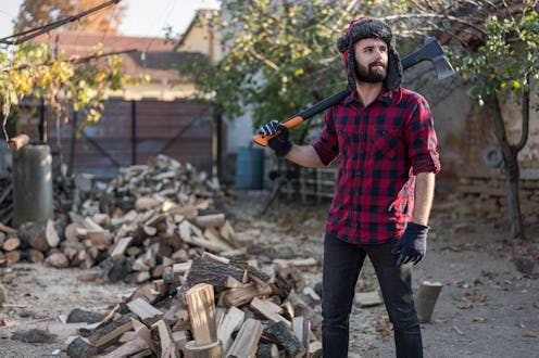 Young male holding big axe and looking away