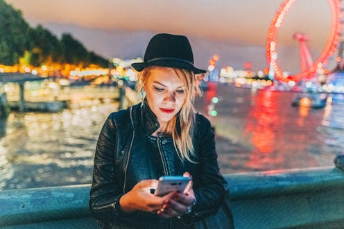 Woman in the city of London using mobile app for taxi calling