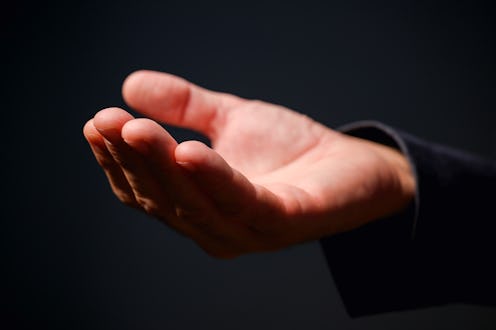 Male hand with palm up, businessman in suit with empty hand as mockup copy space, selective focus