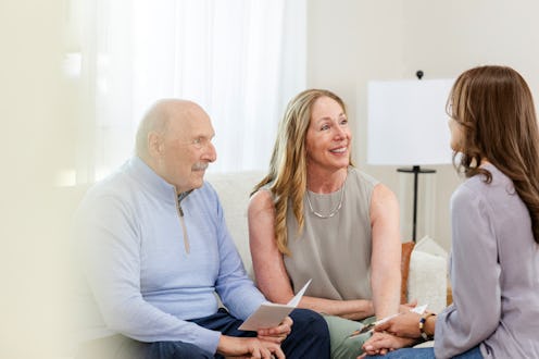 The unrecognizable adult daughter sits with her parents in the living room to talk to them about mov...