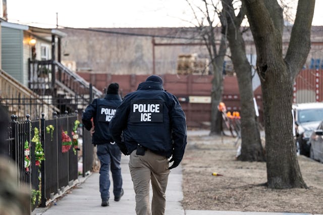 US Immigration and Customs Enforcement (ICE) agents walk down a street during a multi-agency targete...