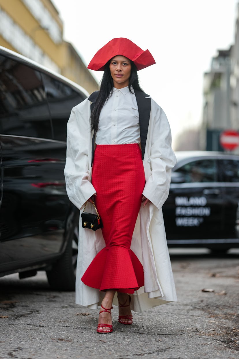 Милан, Италия - 26 февраля: гость носит блестящую вишневую красную шляпу с пиратом, белый запейп -шир ...