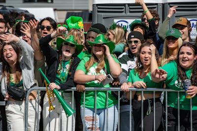 Revelers dressed in green wave during the Boston St. Patrick’s Day and Evacuation Day Parade in Bost…