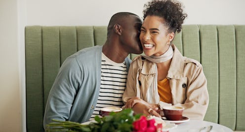 Couple, coffee shop and happy on date with kiss on conversation, support and bonding on valentines d...