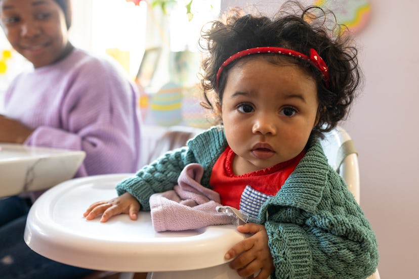 A baby girl sitting in a high chair